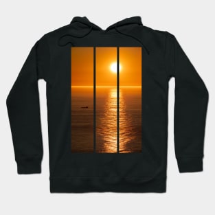 Wonderful landscapes in Norway. Nord-Norge. Beautiful scenery of a midnight sun sunset at Nordkapp (Cape North). Boat and globe on a cliff. Rippled sea and clear orange sky. (vertical) Hoodie